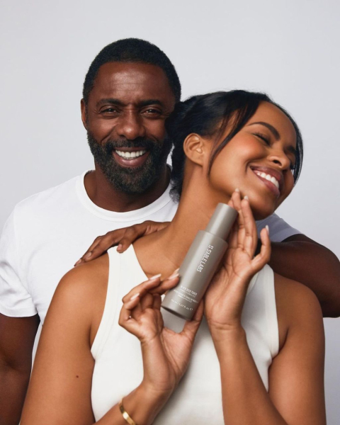 Idris and Sabrina Elba posing with Sabrina holding a skin care bottle